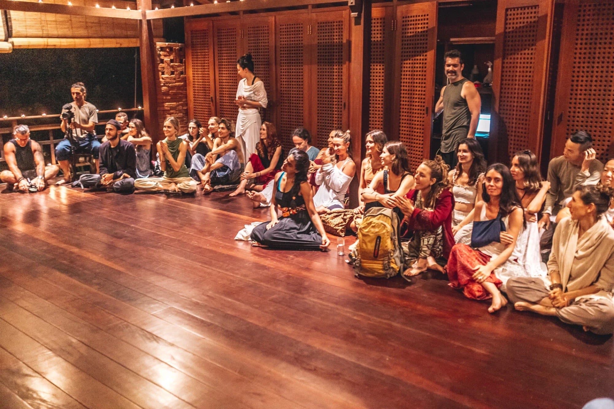 A community gathered in a warm wooden hall at dusk
